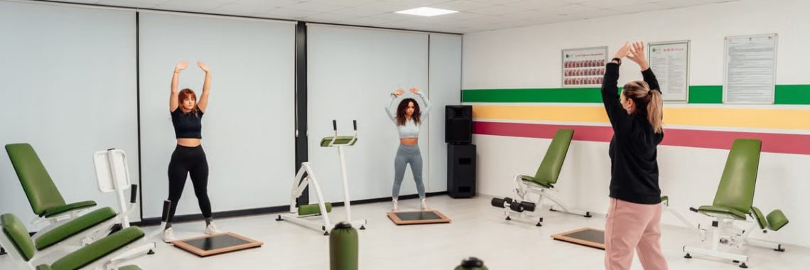 Three women engage in a workout session in a brightly lit, modern fitness studio in Yalova, Türkiye.